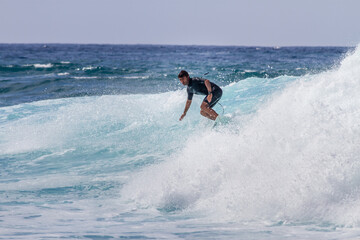 Tenerife, Spain 02 11 2013: Young man bodyboarding on a big wave with white foam. Blue sky. Surfing day. Atlantic Ocean. Tenerife, Canary Islands, Spain.