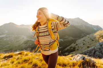 Woman Traveler standing at mountains with backpack admiring landscape. Travel Lifestyle. Concept adventure summer vacations outdoor.