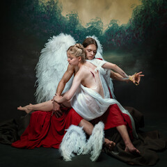 Dramatic scene between man and woman. Man cutting female angel wings with scissors. Sacrifice,...