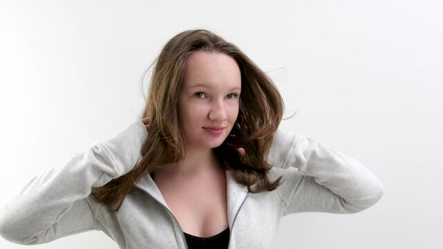 Straighten hair. seminude woman demonstrates healthy silky hair in a studio on a red background. The straight, long hair of a woman flutters in the wind. Keratin straightening. Slow motion.