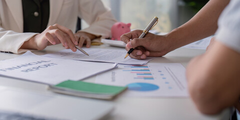 Gay Couple Planning Finances Together at Home with Financial Report and Charts on the Table