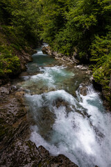 Vintgar Gorges Park a few km from Lake Bled, Slovenia. Wooden walkways accompany the path above the river rapids and waterfalls. River hits rocks and creates fog.Adventure family holidays. Freshness.