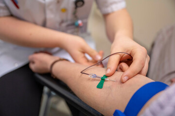 A healthcare professional is inserting an intravenous line into a patient's arm for medical treatment.