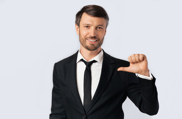 Confident Business Guy Pointing Thumbs At Himself Posing Over White Background. Studio Shot, Isolated