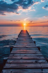Obraz premium Stunning Sunset Over Serene Lake with Wooden Pier Leading into Calm Waters Under a Vibrant Sky