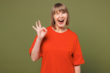 Elderly smiling blonde woman 50s years old she wear orange t-shirt casual clothes showing okay ok...