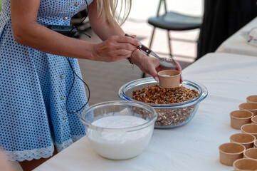 Woman preparing yogurt parfait at food market. Background with selective focus and copy space.