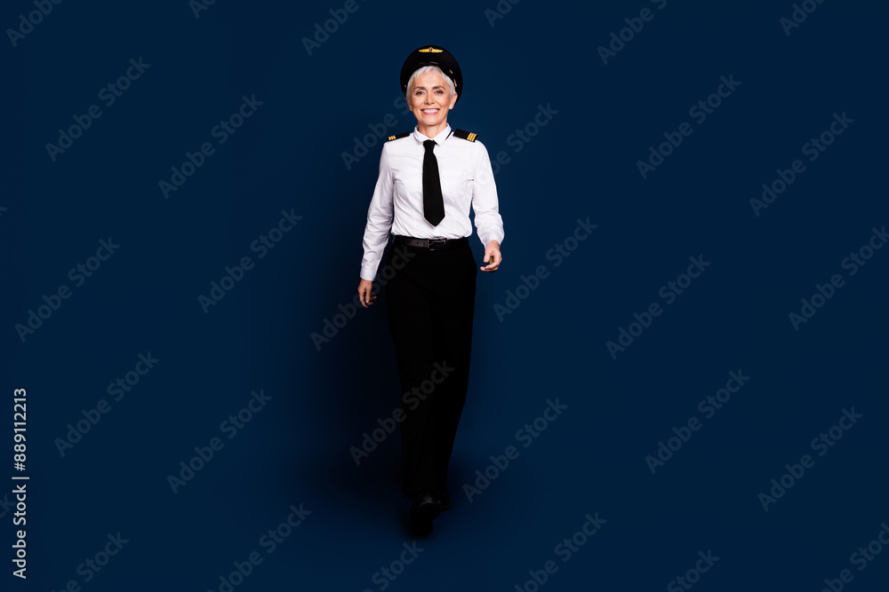 Poster Full body photo of attractive senior woman passenger plane captain walking dressed aviator uniform isolated on dark blue color background