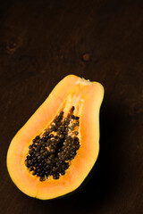 Half of a ripe papaya on a brown background