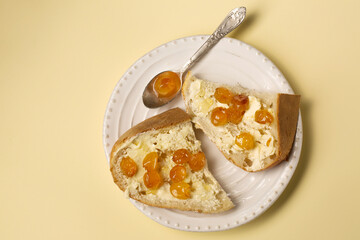 Dessert of homemade bread, butter and cherry jam on a white plate