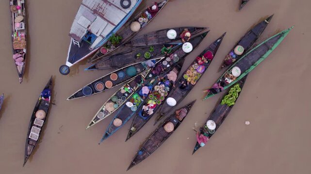 Aerial view of bustling floating market with boats and vendors at Lok Baintan, Banjarmasin, South Kalimantan, Indonesia.