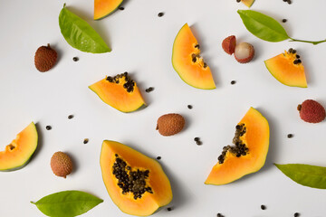 Ripe papaya and litchi on a white background