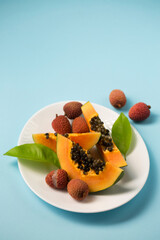 Juicy papaya and lychee on a blue background
