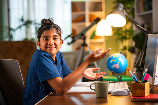 Asian Indian school girl studying at home on computer