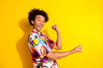 Portrait of nice young man raise fists wear shirt isolated on vivid yellow color background