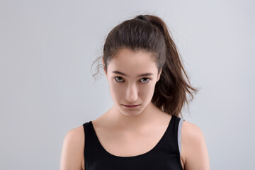 Young woman with ponytail making angry face expression