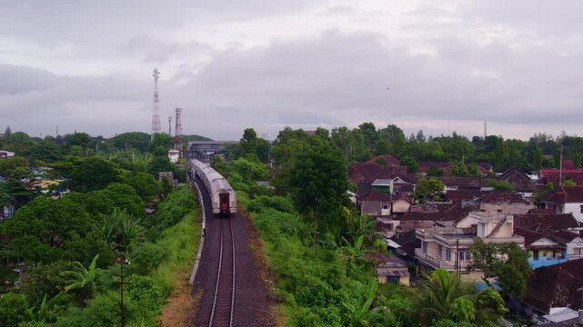 Aerial view of colourful Kampung Jodipan with train track and rooftops, Malang City, East Java, Indonesia.