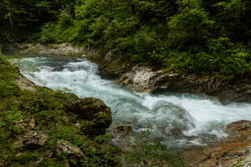 Vintgar Gorges Park a few km from Lake Bled, Slovenia. Wooden walkways accompany the path above the river rapids and waterfalls. River hits rocks and creates fog.Adventure family holidays. Freshness.