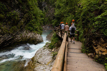 Vintgar Gorges Park a few km from Lake Bled, Slovenia. Wooden walkways accompany the path above the river rapids and waterfalls. River hits rocks and creates fog.Adventure family holidays. Freshness.