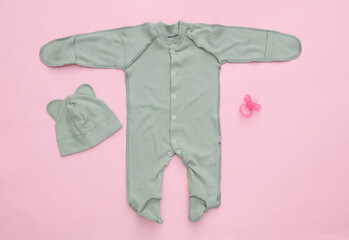 Newborn baby clothes on a pink background. Top view. Flat lay