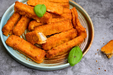 Close up of   Crispy breaded  deep fried fish fingers with breadcrumbs served  with remoulade sauce and  lemon Cod Fish Nuggets on rustic wood table background