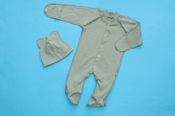 Newborn baby romper and hat on blue background. Top view. Flat  lay