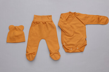 Newborn baby clothes on gray background. Top view. Flat lay