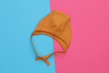 Newborn baby hat on blue pink background
