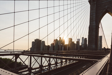 Brooklyn Bridge at sunset with Manhattan skyline on the background