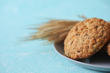 Cereal cookies with ears of wheat on blue concrete background
