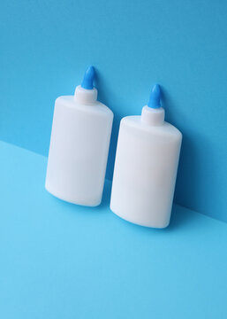 Two bottles of pva glue on blue background