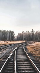 Fototapeta premium A view down the middle of train tracks as they split at a crossing. The tracks are surrounded by gravel and grass