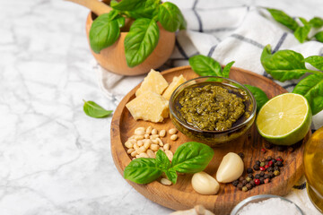 Pesto. Italian basil pesto sauce on a textured wooden background. Ingredient for pesto sauce: fresh...