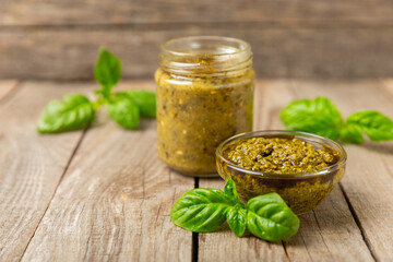 Pesto. Italian basil pesto sauce on a textured wooden background. Ingredient for pesto sauce: fresh...
