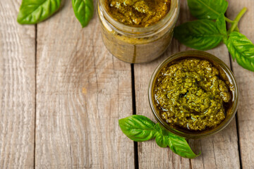 Pesto. Italian basil pesto sauce on a textured wooden background. Ingredient for pesto sauce: fresh...