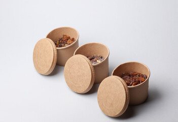 Disposable cardboard boxes, food containers with oatmeal and raisins on a white background.