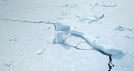 Frozen Antarctic ocean surface with snow covered icebergs, glaciers, mountains in background....