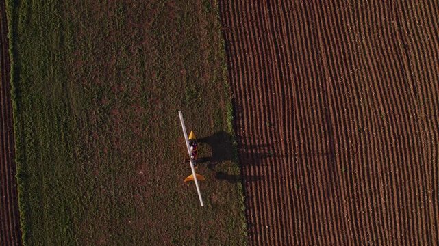 Aerial view of sunset over gyrocopter flying above meadow in Ginosa, Taranto, Italy.