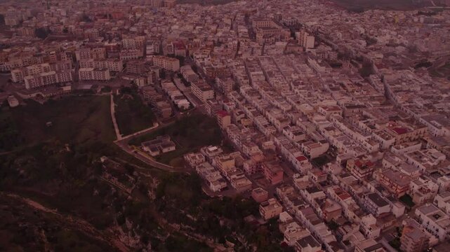 Aerial view of foggy cityscape at sunrise, Ginosa, Italy.