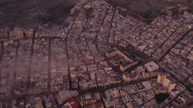 Aerial view of sunrise over city with clouds, Ginosa, Italy.