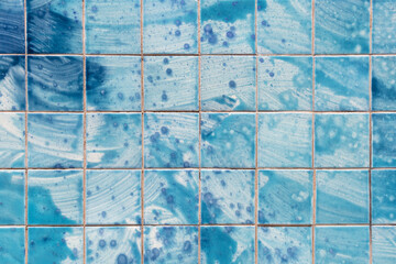 Tiles on the wall of a building with an abstract blue pattern