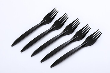 Black plastic forks on a white background