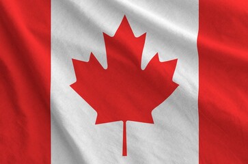 Canada flag depicted on folded wavy fabric of old cloth close up