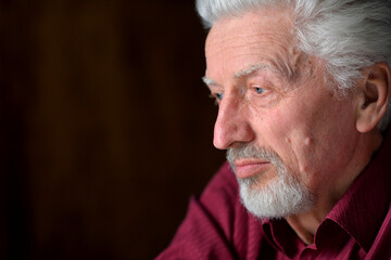 close-up portrait of a senior man thinking about something