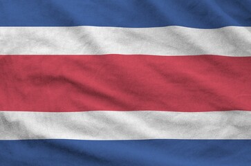 Costa Rica flag depicted on folded wavy fabric of old cloth close up
