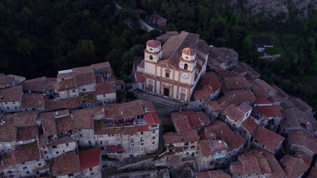 Aerial view of Santo Stefano church and village rooftops in sunrise fog, Artena, Italy.
