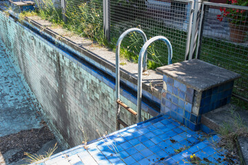 Abandoned old swimming pool without water