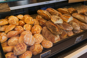 Diversi tipi di pane esposti in vetrina da vendita da un panificio