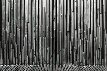 Wall with narrow dark gray steel bars forming vertical patterns