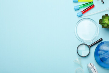 Laboratory glassware (Test tubes with flask) and accessories on blue background. Top view. Flat lay. Copy space